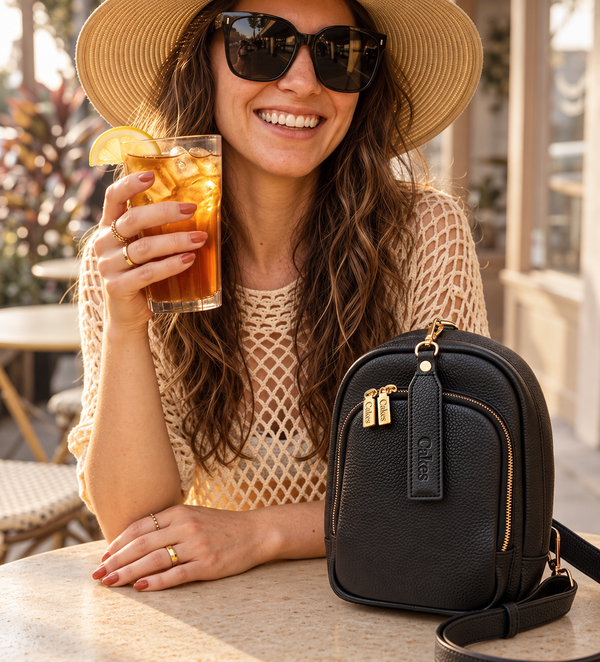 How to conceal carry in the summer: woman in a sun hat with an iced drink and a black leather concealed carry purse