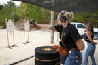 Woman practicing a safe concealed carry draw with an unloaded, verified-clear firearm during a training session