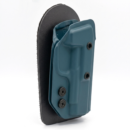 BLUEBERRY CAKES CONCEALED HOLSTER ON A BLACK VELCRO BACKER ANGLED TO THE SIDE. 