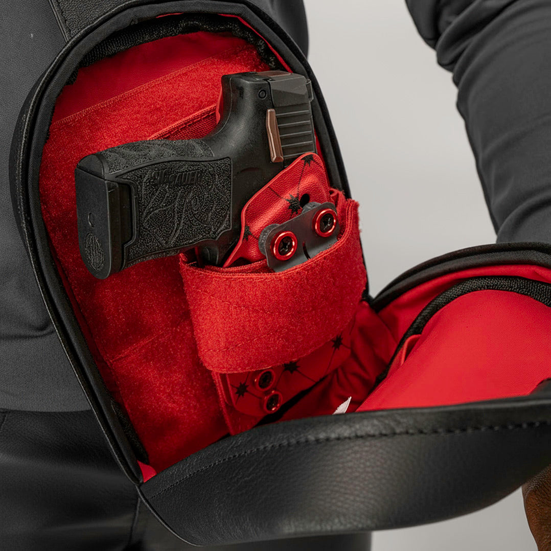 Close-up of a red jacket with a gun holster inside, on a neutral background.
