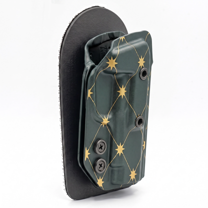 CAKES CONCEALED GOLD PREMIUM HOLSTER ON A BLACK VELCRO BACKER ANGLED.