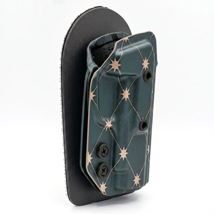 CAKES CONCEALED ROSE GOLD PREMIUM HOLSTER ON A BLACK VELCRO BACKER ANGLED.